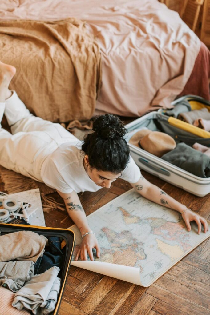 A Woman lying on the floor looking of a travel map