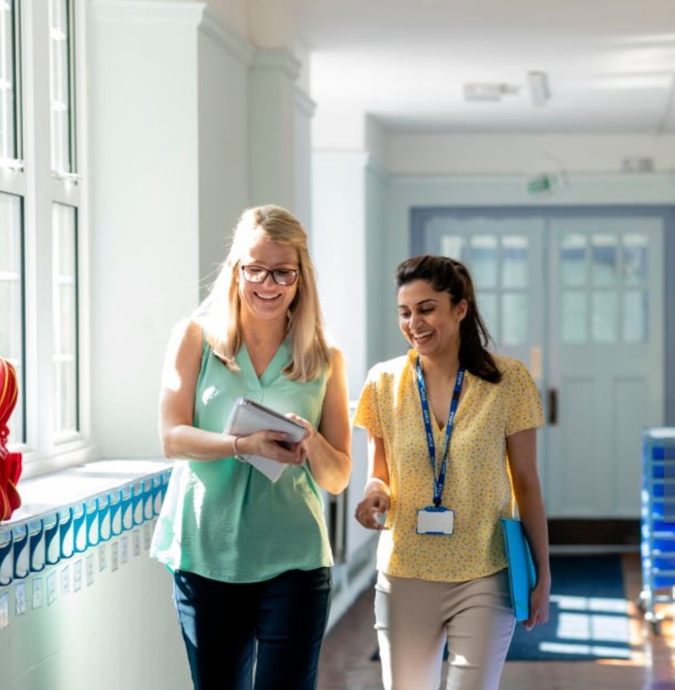 Two teachers walking in a school hallway