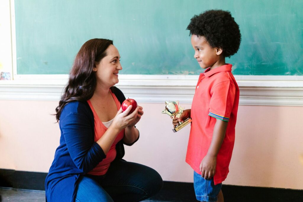 Women teacher with her Student in front of a chalkboard